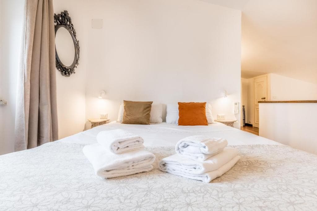 Mezzanine double bedroom with ornate mirror and soft natural light