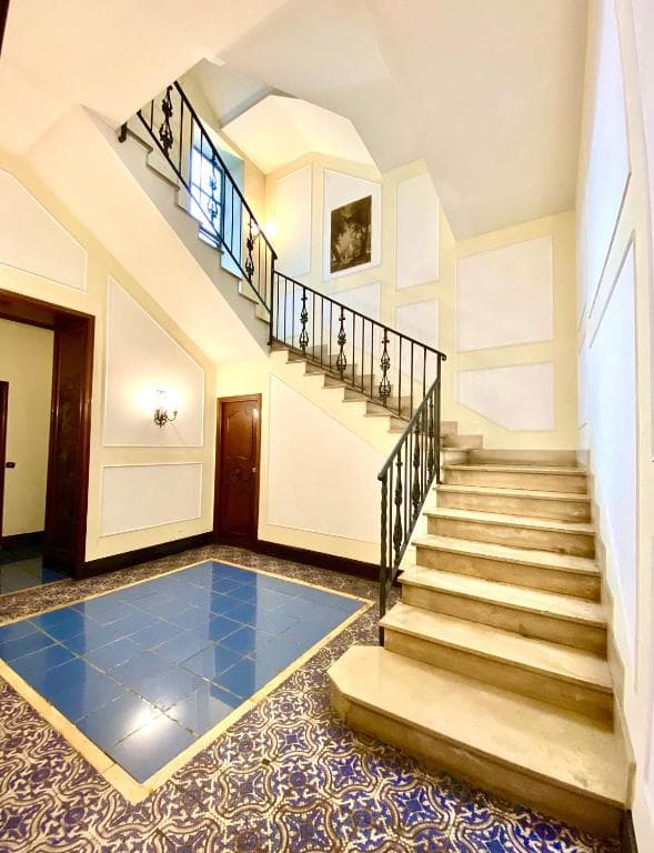 Communal stairwell with marble steps and a blue majolica landing