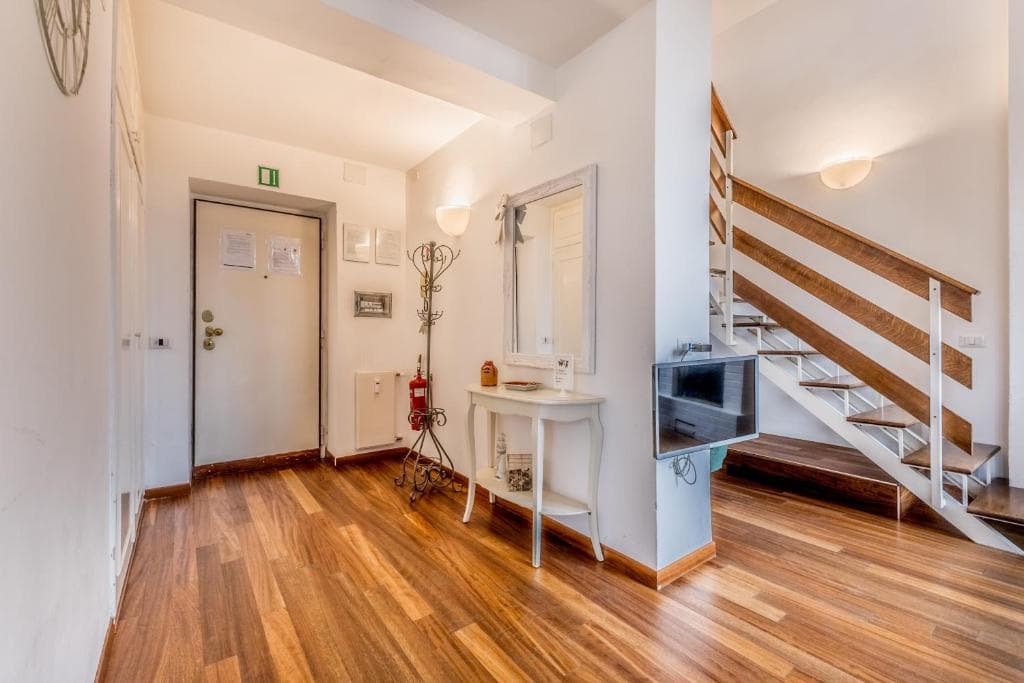 Entrance hall with mirror and console, opening to the living area and staircase