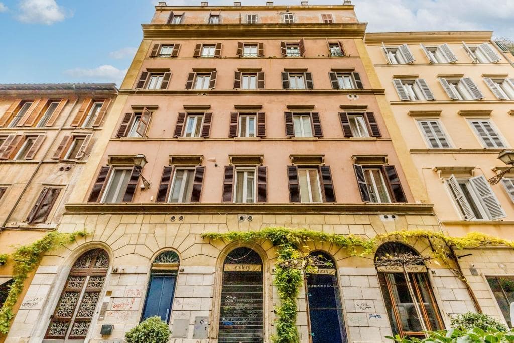 Pink-ochre historic facade of the building on Via della Frezza