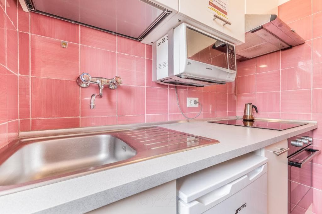 Kitchen with stainless-steel sink, microwave and worktop