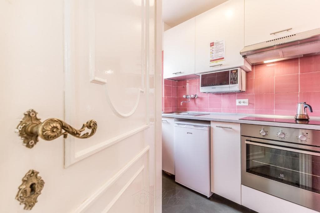 Kitchen glimpsed through an ornate panelled door