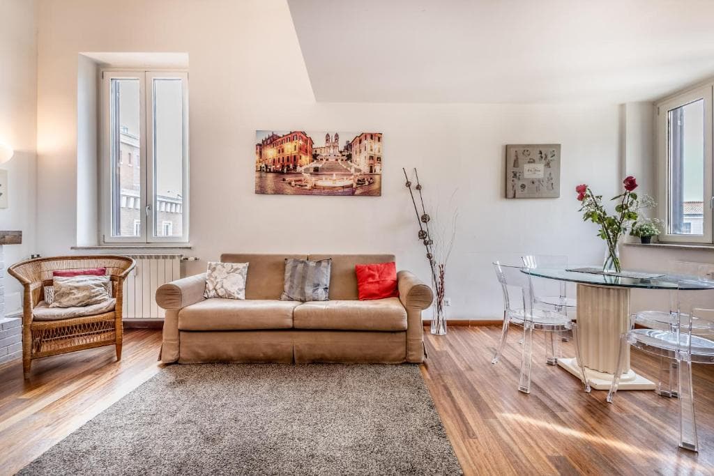Sunlit living room with sofa and dining area, parquet floors