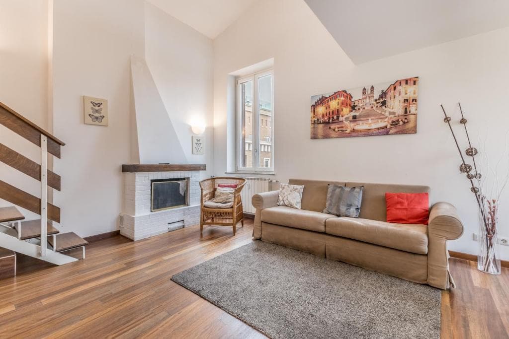 Living room with fireplace and internal staircase under a double-height ceiling