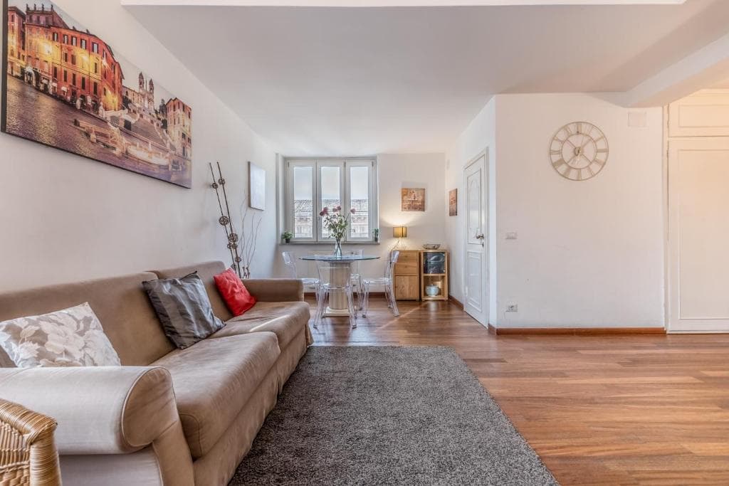 Airy living room with sofa, dining table and wall clock